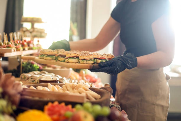 Catering staff arranging food trays at an event